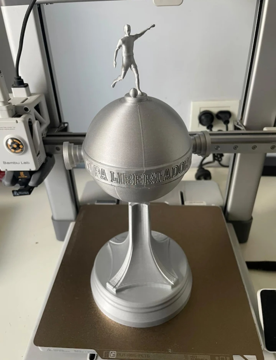 Réplica impresa en 3D de un trofeo con figura de jugador, en plata